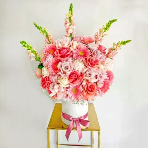 Ramo de flores rosadas con rosas, gerberas y crisantemos, diseño elegante y delicado en base blanca, ideal para regalar con amor.