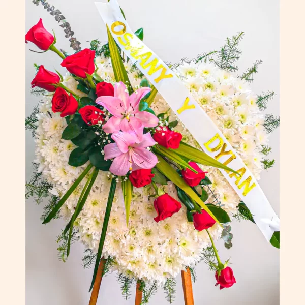 Hermoso Arreglo Fúnebre con forma de corazón con rosas rojas, lirios rosados y pompones blancos para funerales de difuntos en Bogotá.