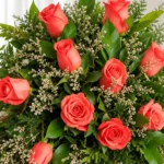 Detalle de las rosas coral con caspia y follaje de la Corona Funebre Memoria