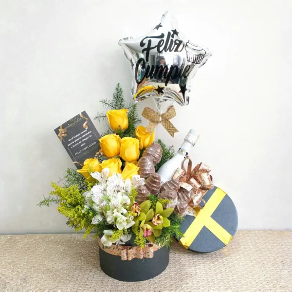 Ramo de cumpleaños con rosas amarillas, orquídeas verdes, astromelias blancas, globo metálico y vino en caja elegante.
